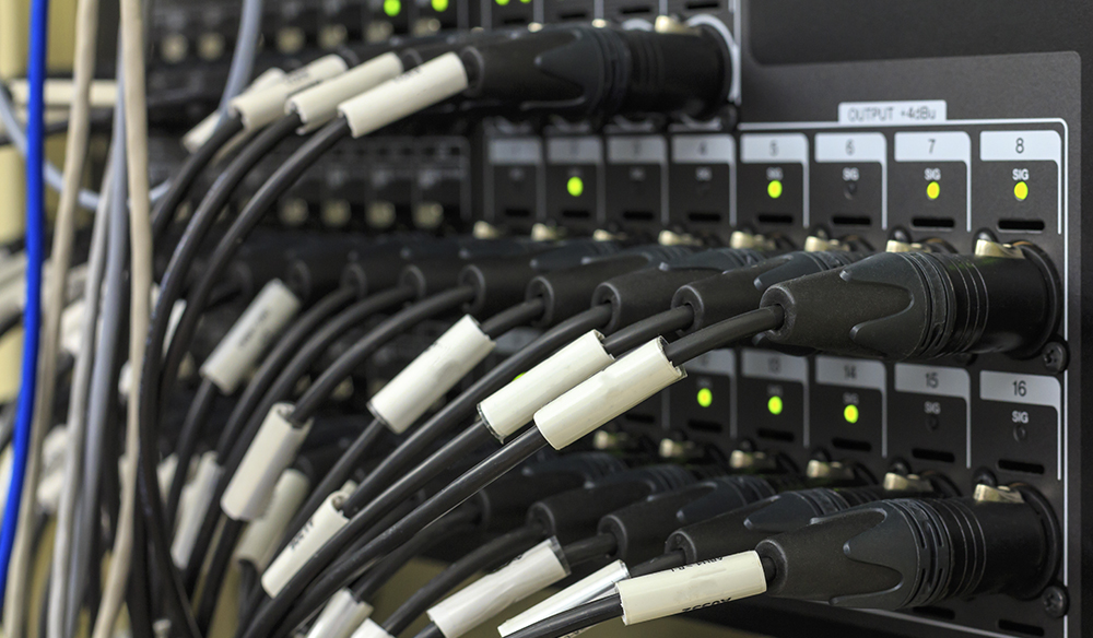 Vidéaste professionnel vérifiant les connexions HDMI de son setup de tournage extérieur